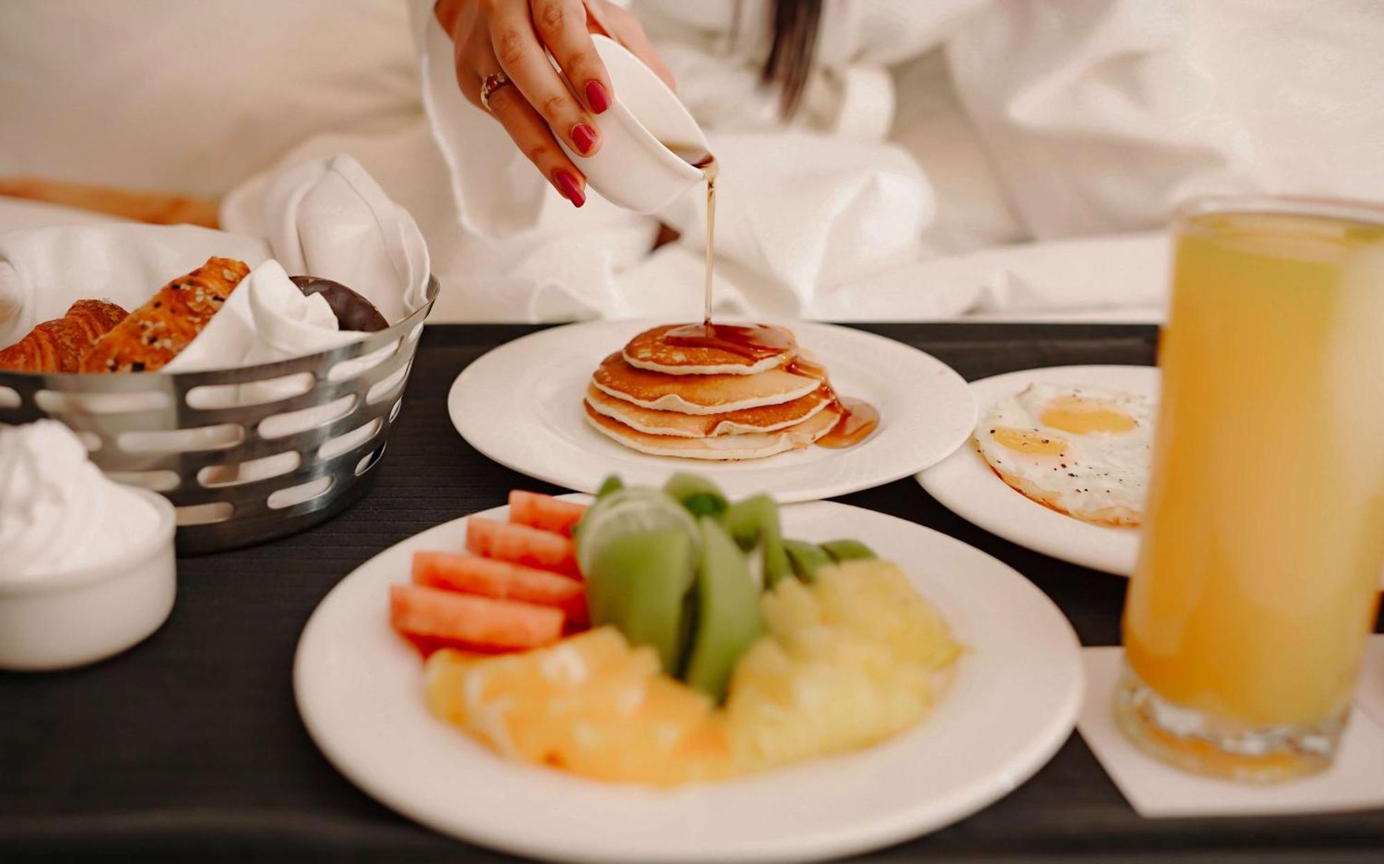 فندق راديسون بلو أمريستار أمريتسار المظهر الخارجي الصورة A woman pouring maple syrup on a stack of pancakes